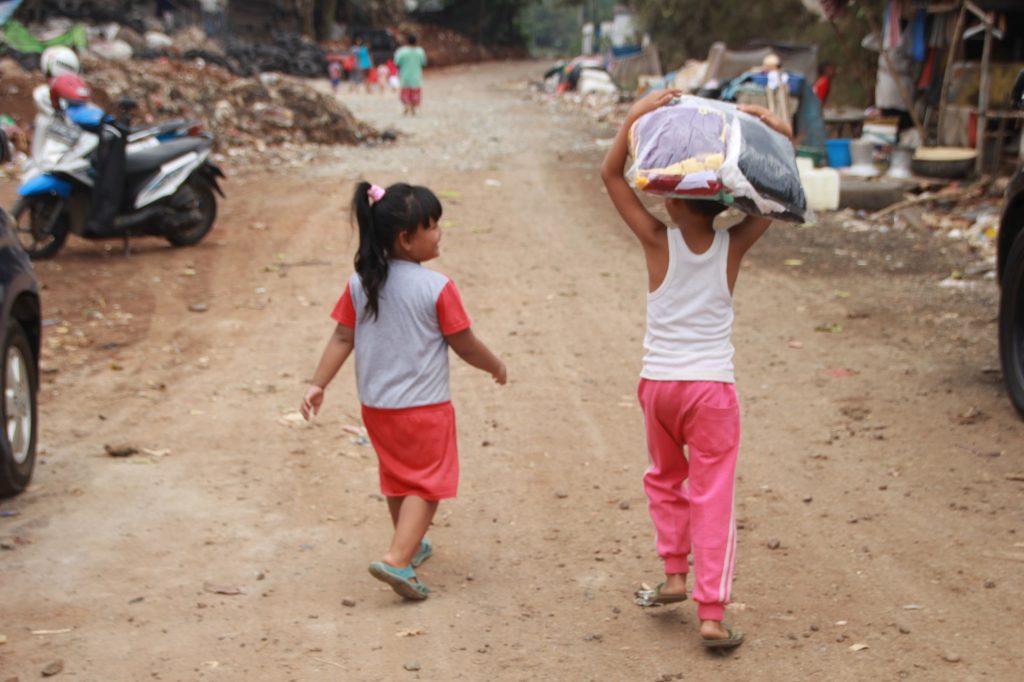 Anak-Anak Membawa Baju Layak Pakai dari Aksi Sosial PDAM Tirta Bhagasasi