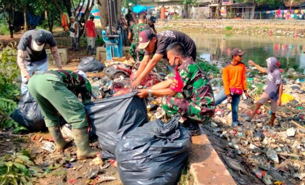 Puluhan Prajurit TNI dari Kodim 0509/Kabupaten Bekasi Bergotong Royong Membersihkan Sampah yang Tersangkut di Area Pintu Air Kali Bancong Kecamatan Sukatani